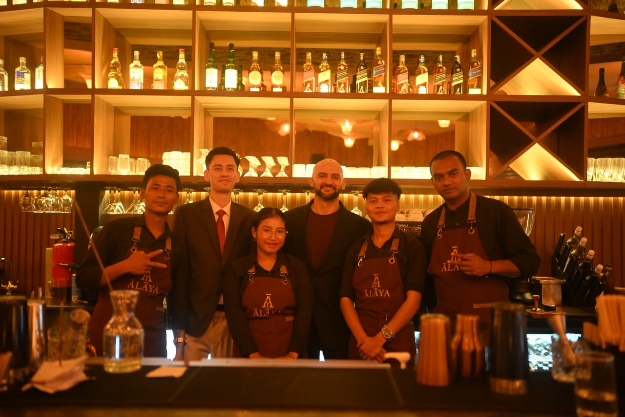Rish Saini behind the Ālaya bar with the bar team in branded aprons