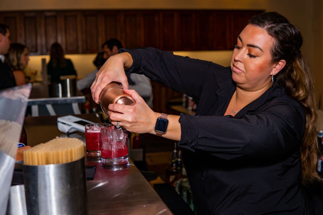 A bartender pouring a drink at a holiday party