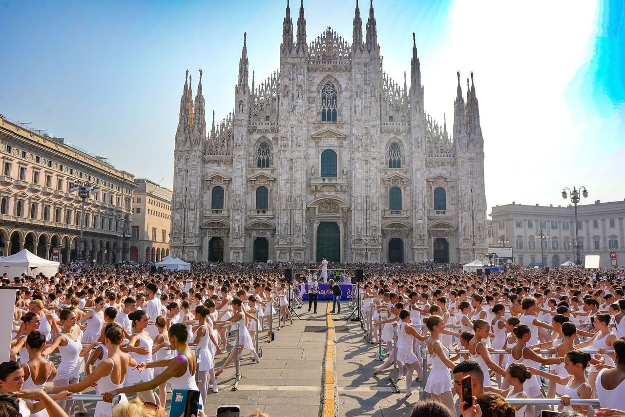 Dancers dressed in white filling the square in front of Milan Cathedral