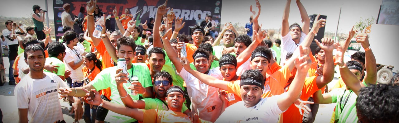 Runners in Desi Warrior T-shirts cheering with their arms raised