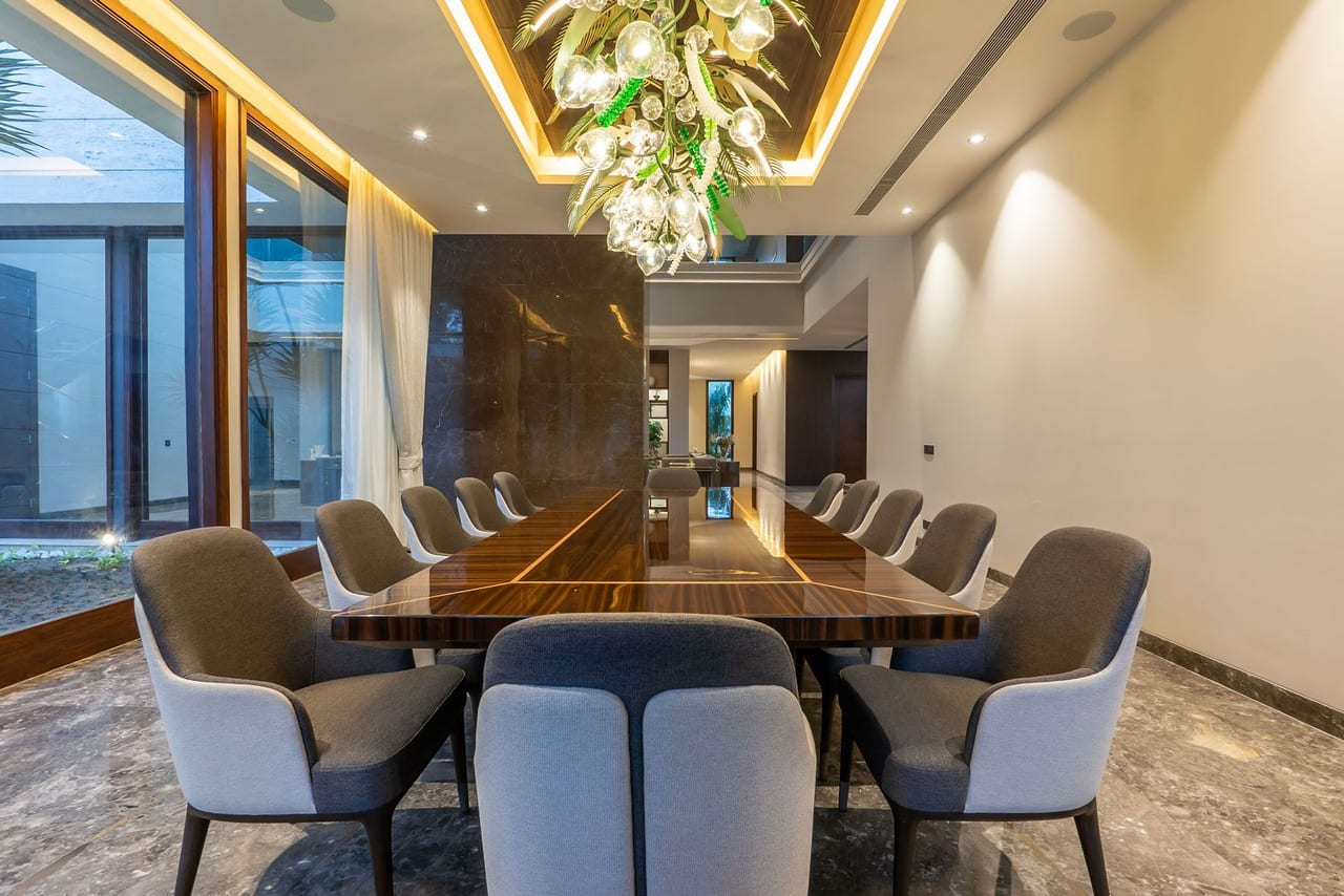 A dining table beneath a sculptural chandelier