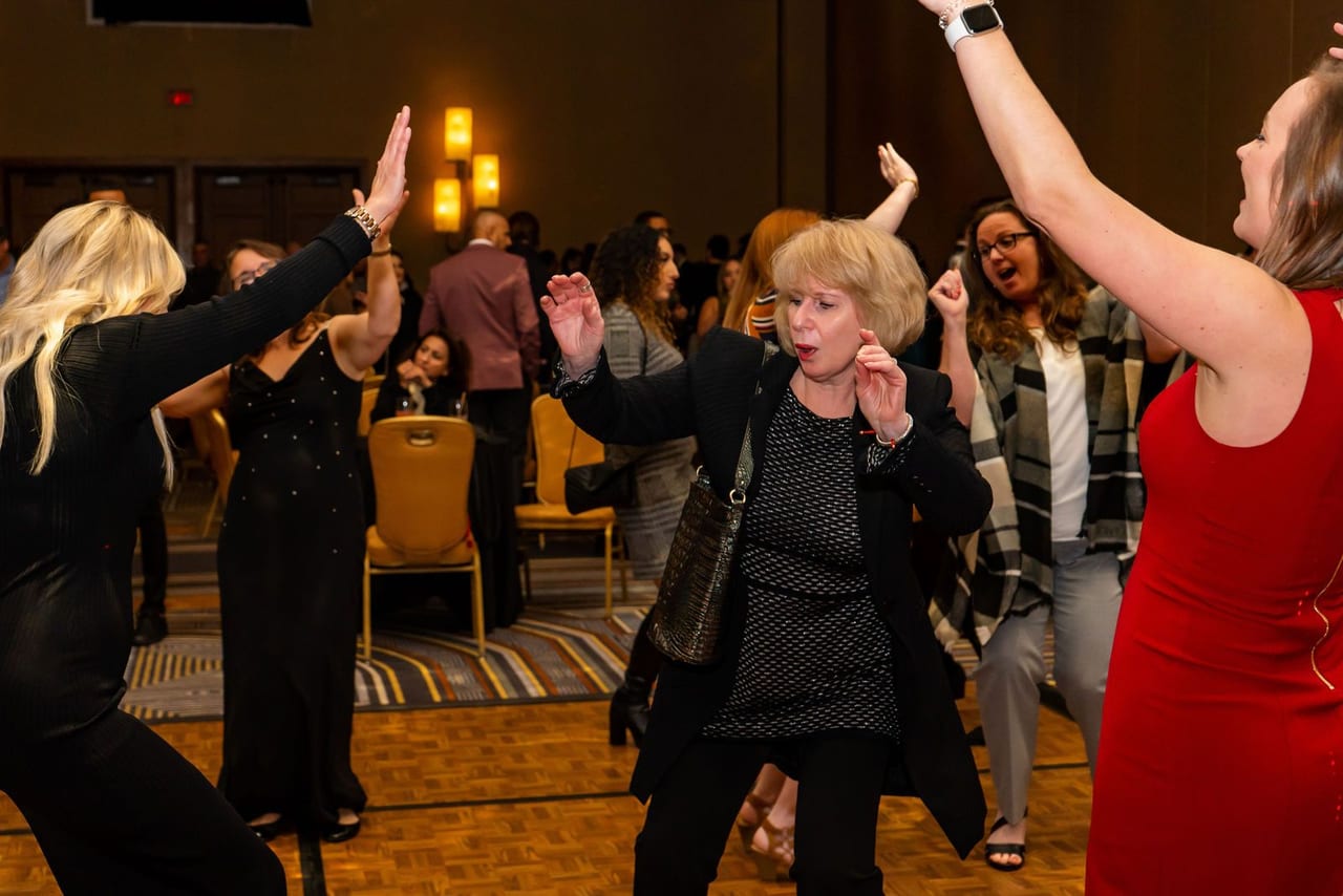 Guests dancing with their arms in the air on a crowded dance floor