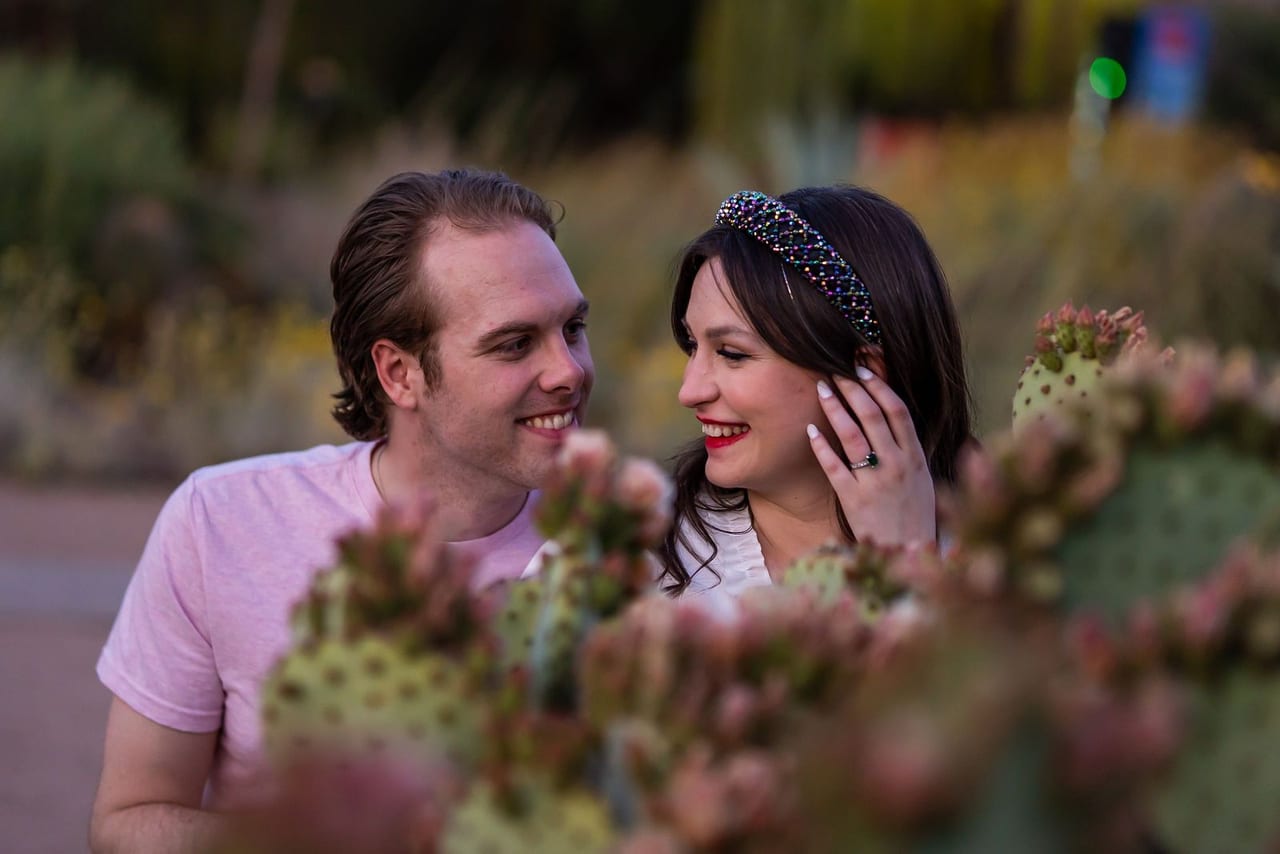 A laughing couple seen through cactus blooms
