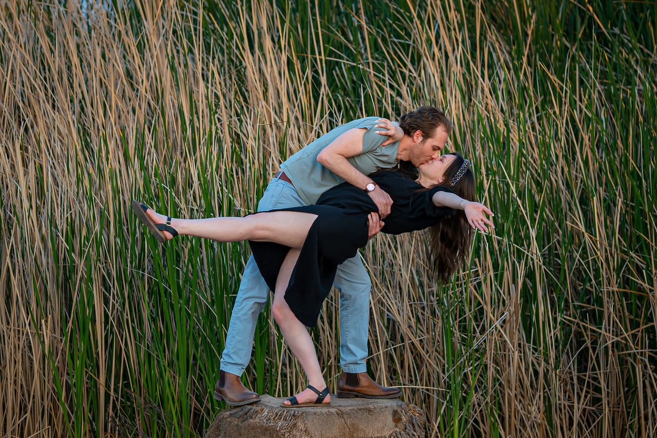 A man dipping his partner among tall desert grasses