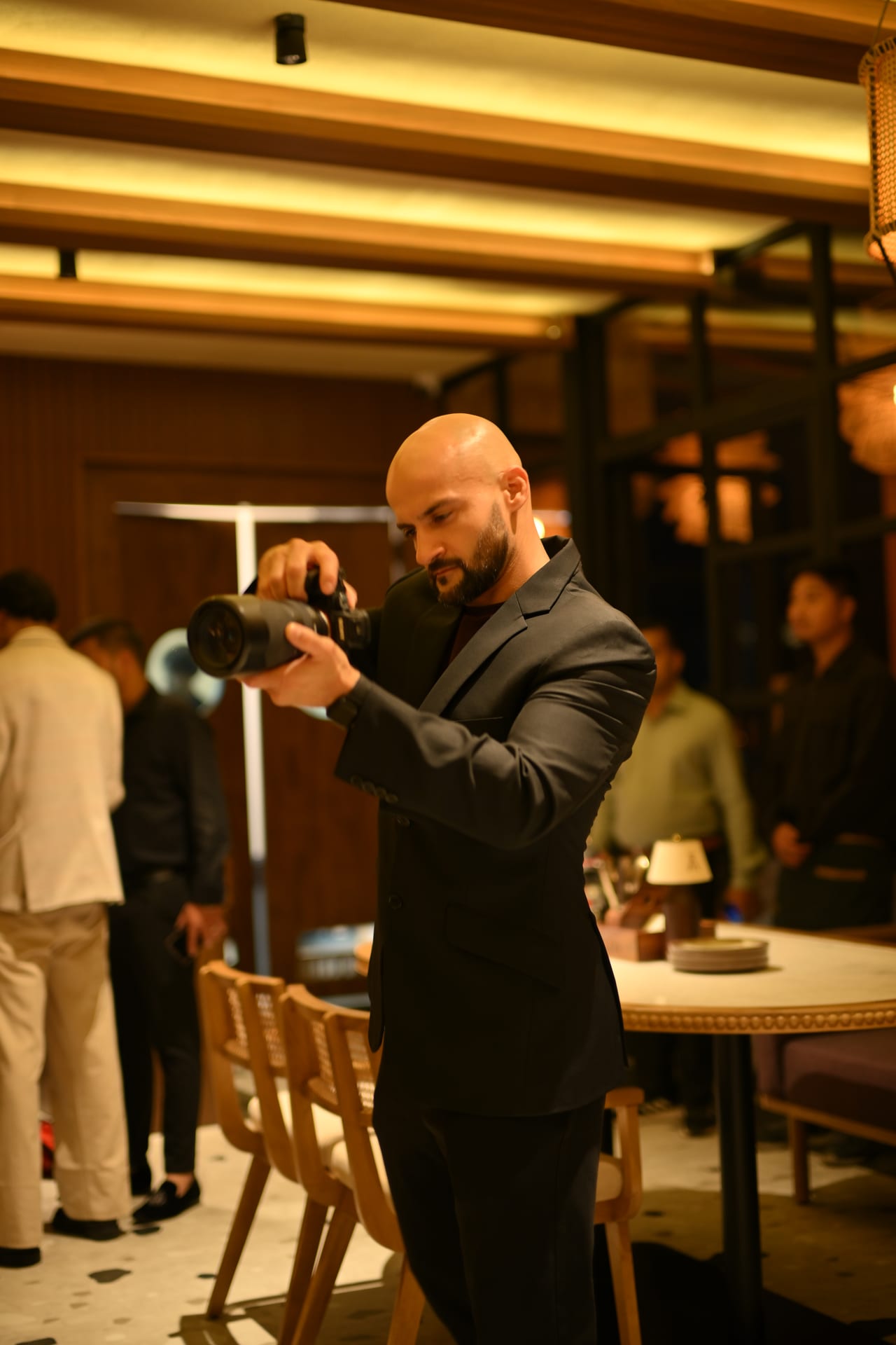 Rish Saini photographing the dining room at Ālaya Café & Bar with his camera