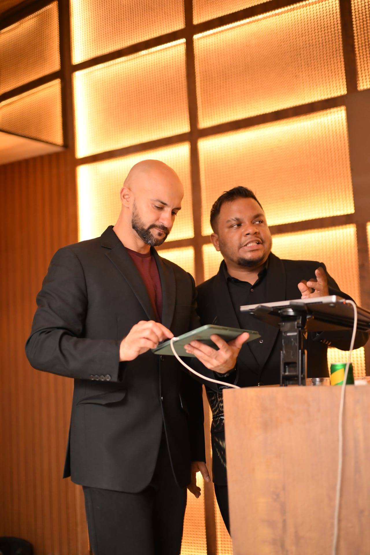 Rish Saini reviewing a tablet with a colleague at the host stand at Ālaya Café & Bar