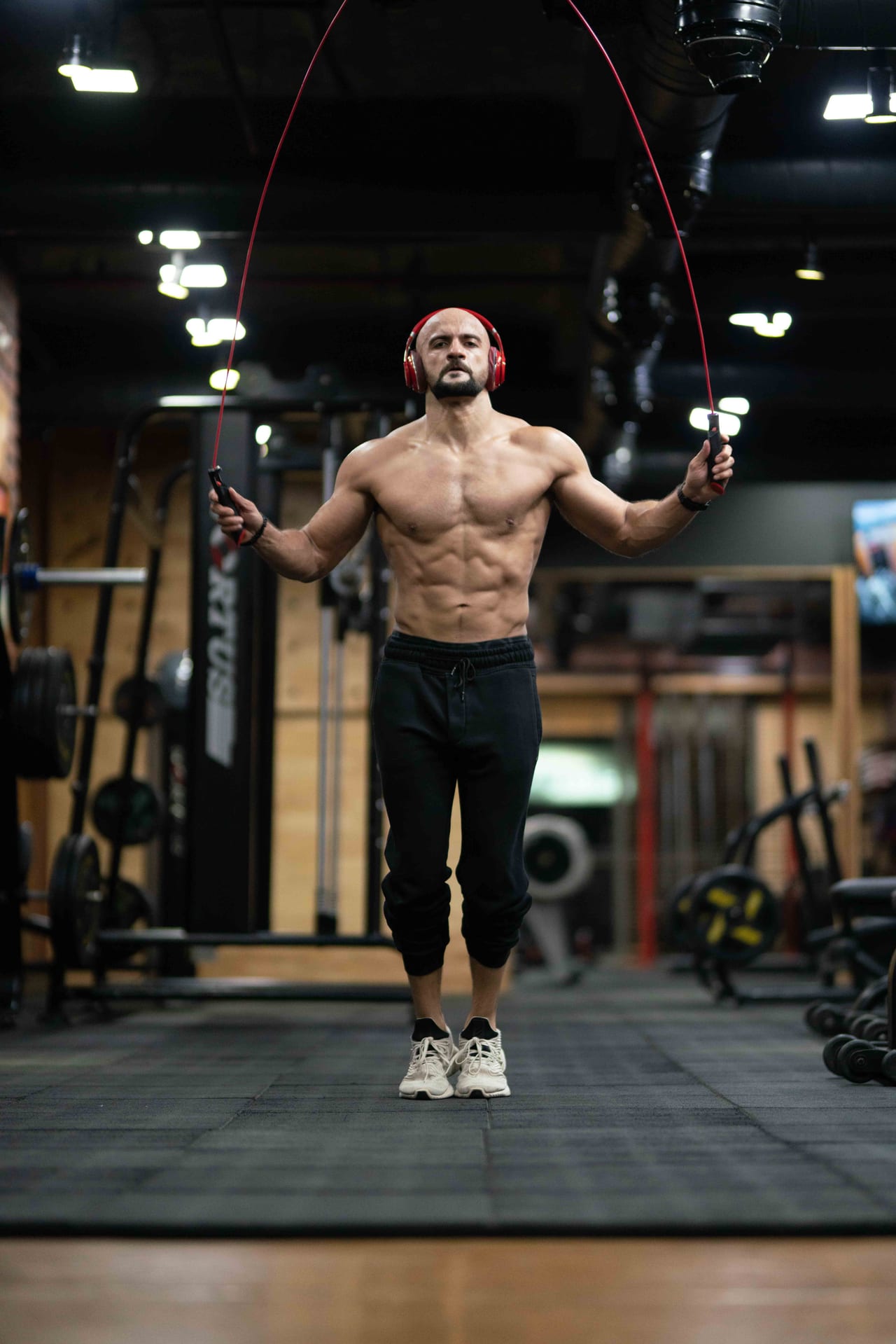 Rish Saini skipping rope in a gym, wearing headphones