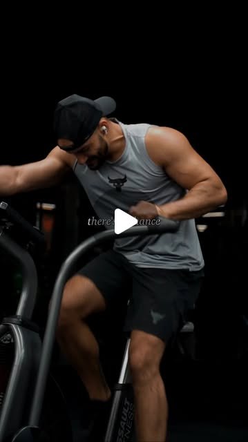 Rish Saini on an air bike in a gym, in a grey vest and cap