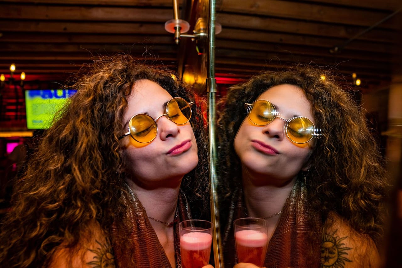 Two women in matching tinted sunglasses pouting for the camera