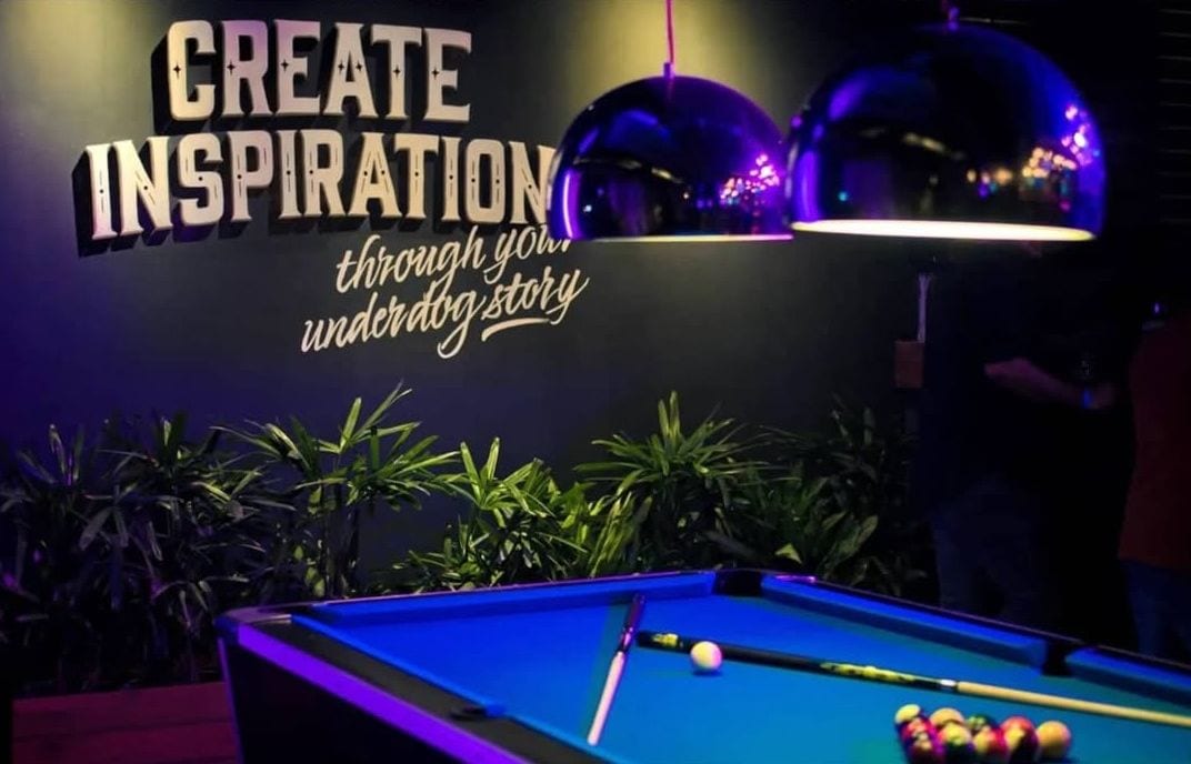 A pool table under a wall painted Create Inspiration at Underdoggs Jalandhar